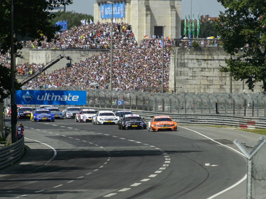 Race cars on the track during the Norisring race in Nuremberg in front of a packed grandstand.