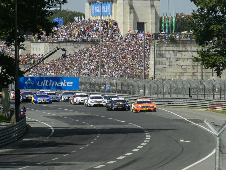 Rennwagen auf der Strecke beim Autorennen am Norisring in Nürnberg vor einer voll besetzten Tribüne.