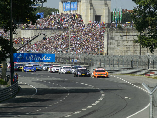 Rennwagen auf der Strecke beim Autorennen am Norisring in Nürnberg vor einer voll besetzten Tribüne.