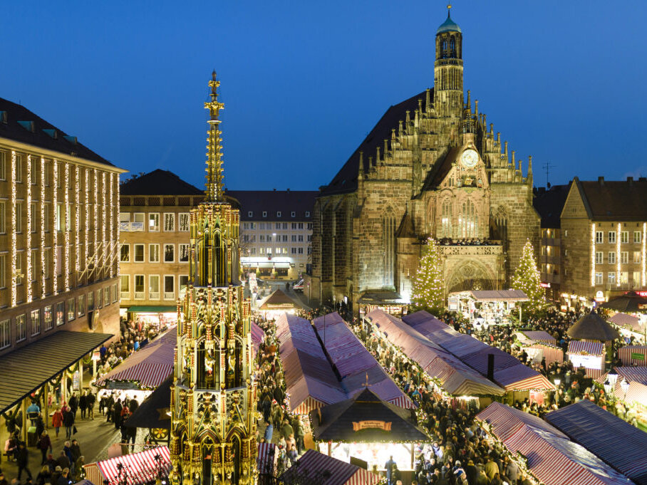 Abendliche Ansicht des Nürnberger Christkindlesmarktes mit Marktbuden und der Frauenkirche.